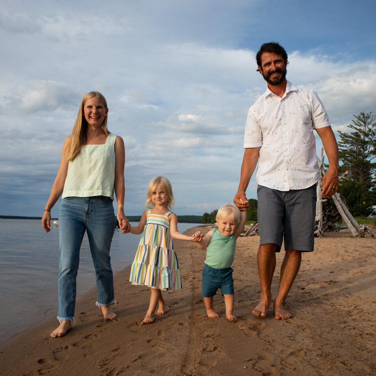 Alison Percowycz, MSN, FNP-C with her husband and two children smiling on a beach