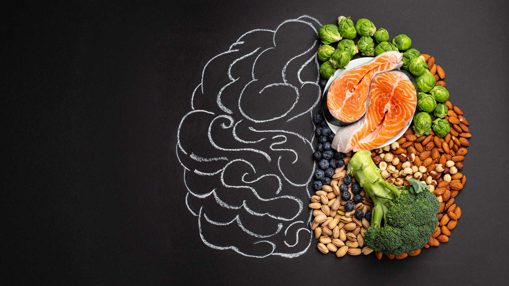 depiction of a brain with half drawn in chalk and the other comprised of vegetables, nuts, and berries