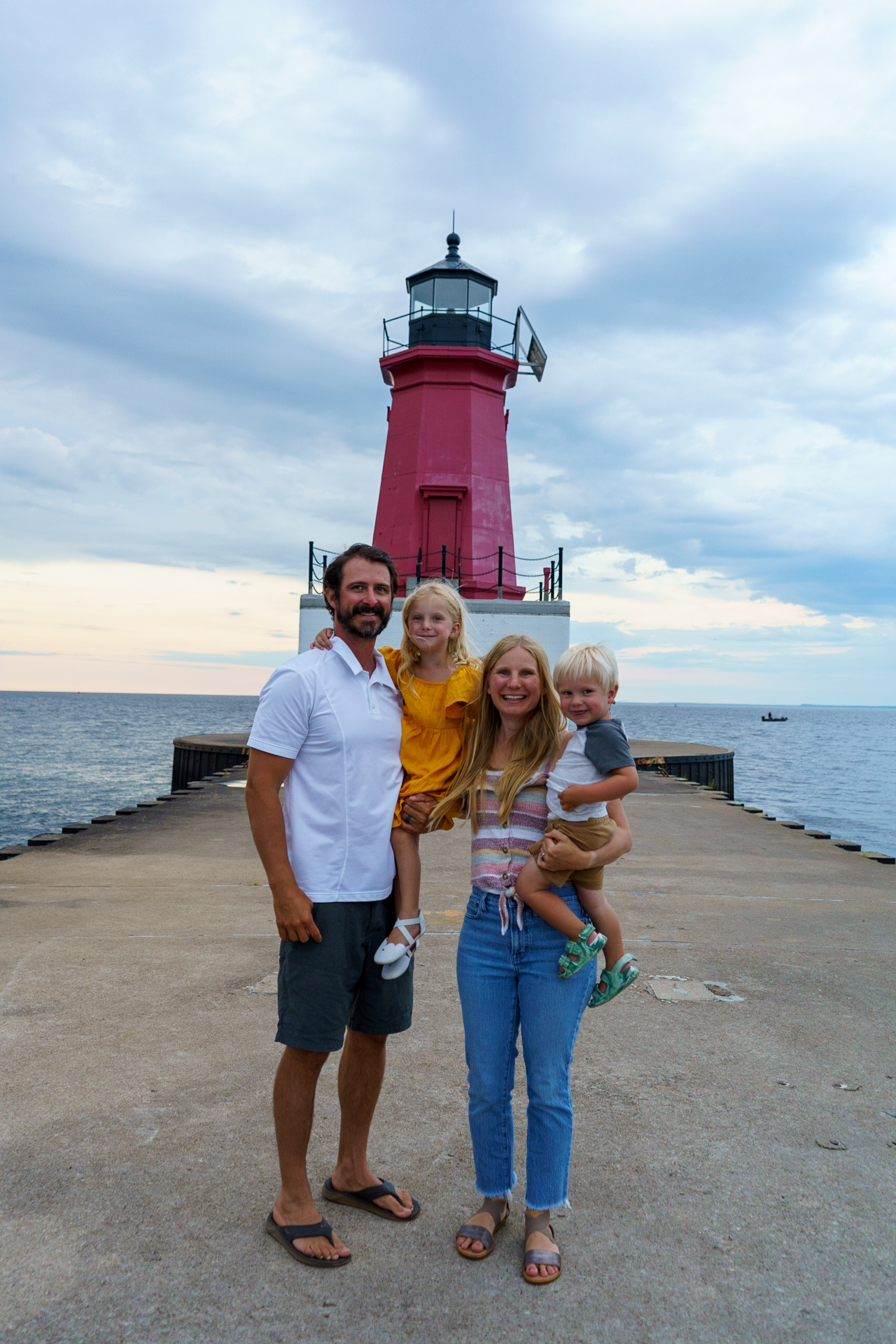Functional Medicine Provider Alison Percowycz, MSN, FNP-C with her husband and two children in front of a lighthouse.